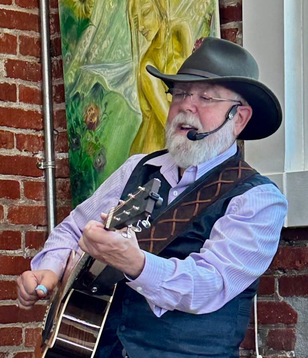 Mr. Dave singing at Brickhouse Coffee, while playing his acoustic guitar.